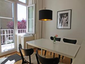 ein Esszimmer mit einem weißen Tisch und Stühlen sowie einem Fenster in der Unterkunft WOLKE, Apartment Zimmer, Zentrum, am Fluss, Parkplatz in Bad Ischl