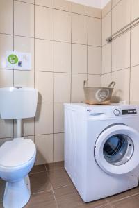 uma casa de banho com uma máquina de lavar roupa e um WC em Studio on the closest beach to the city! em Amoudara Herakliou