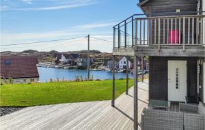 a house on a wooden deck with a body of water at Nice Home In Bremnes With Wifi in Bremnes +10 photos