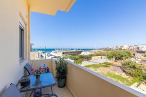 a balcony with a table and a view of the ocean at Studio on the closest beach to the city! in Amoudara Herakliou