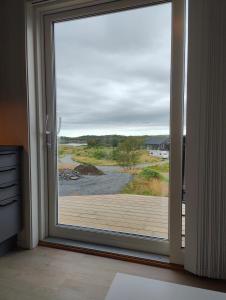 a sliding glass door with a view of a beach at Torghatten bnb in Brønnøysund +5 photos