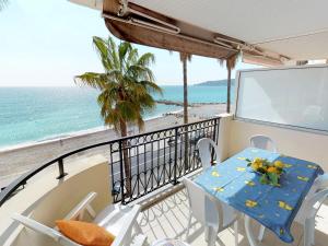 a table and chairs on a balcony with a view of the ocean at Superbe 3P en bord de mer avec terrasse et garage à Menton - FR-1-196-248 in Menton