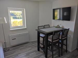 a room with a table and two chairs and a television at Ferienwohnung Dani in Köttmannsdorf