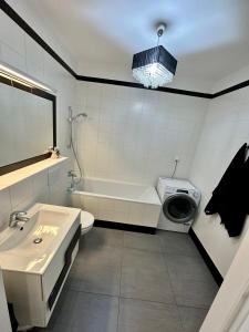 a bathroom with a sink and a toilet and a washing machine at Browar Lubicz Free GARAGE in Kraków