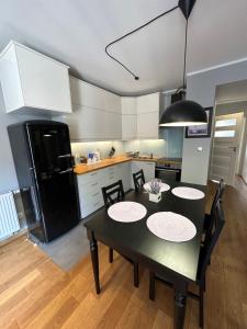 a kitchen with a black table and a black refrigerator at Browar Lubicz Free GARAGE in Kraków