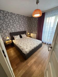 a bedroom with a bed and a lamp and wooden floors at Browar Lubicz Free GARAGE in Kraków
