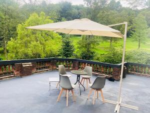 una mesa y sillas bajo una sombrilla en un patio en Green Gables Hotel, en Scarborough