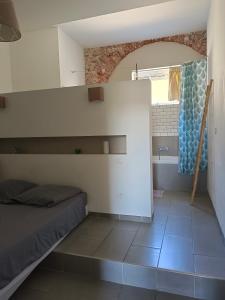ein Schlafzimmer mit einem Bett und ein Bad mit einem Fenster in der Unterkunft Quetzal in Perpignan