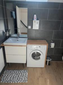 a bathroom with a washing machine and a sink at Ferienwohnung Dani in Köttmannsdorf