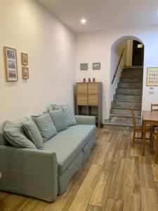 ein Wohnzimmer mit einem Sofa und einer Treppe in der Unterkunft Casa Gaia A due passi dal Duomo in Neapel