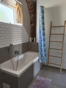 eine Badewanne im Bad mit Fenster in der Unterkunft Quetzal in Perpignan