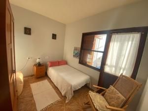 una camera con un letto e una sedia e una finestra di Casa Quintilia a Los Llanos de Aridane