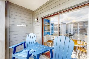 twee blauwe stoelen en een tafel op een balkon bij Myrtle Beach Resort A-332 in Myrtle Beach