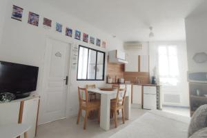 a kitchen with a table and chairs in a room at La Coquille in Sète