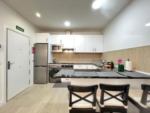 a kitchen with white cabinets and stainless steel appliances at Acogedor Infanta Mercedes in Madrid