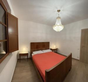 una camera con un grande letto e un lampadario a braccio di Agriturismo Poggio Ajano a Abbazia di Santa Maria in Selva