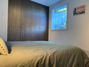 een slaapkamer met een groot bed en een raam bij Appartement Gérardmer in Gérardmer