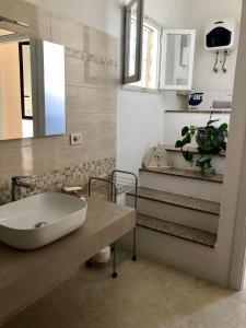 een badkamer met een wastafel en een trap met een spiegel bij La Marchesa di Castiglione in Andrano