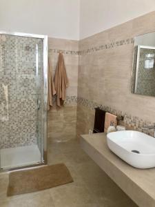 een badkamer met een wastafel en een douche bij La Marchesa di Castiglione in Andrano