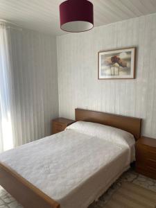 ein Schlafzimmer mit einem Bett und einem Bild an der Wand in der Unterkunft Casa Ameixeira in Carnota