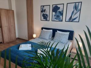 Un dormitorio con una cama azul y una planta en Chabrowa Apartamenty 1, en Milicz