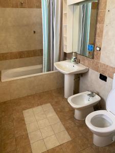 a bathroom with a toilet and a sink and a tub at Olive Tree in Bari