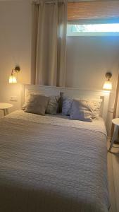 um quarto com uma cama branca com 2 almofadas e uma janela em Apartament Vintage em Mrągowo