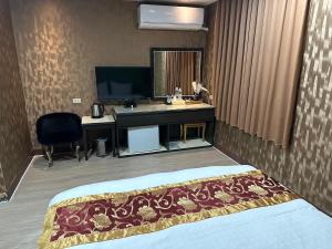 a hotel room with a bed and a sink and a desk at 土城飯店 in Tucheng