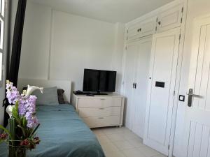 ein Schlafzimmer mit einem Bett und einem Fernseher auf einer Kommode in der Unterkunft 4-room house Las Americas, Las Vistas beach in Playa de las Americas