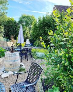 un giardino con tavolo, sedie e botte di vino di The Abbey Hotel a Battle