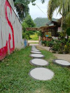 a path with stepping stones in the grass next to a building at MiL's Hillside Tourist Inn in San Vicente