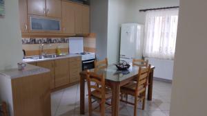 uma cozinha com uma mesa e cadeiras e um frigorífico em HOLIDAYS APARTMENT ΜΕΣΣΗΝΗ em Messini