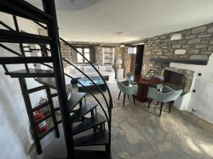 een woonkamer met een trap en een tafel en stoelen bij Villa Aspro Paros 1 in Drios