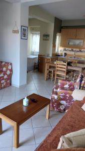 a living room with a coffee table and a kitchen at HOLIDAYS APARTMENT ΜΕΣΣΗΝΗ in Messini