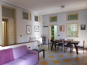 イスピカにあるAppartamento Cantoの紫色のソファとテーブル付きのリビングルーム