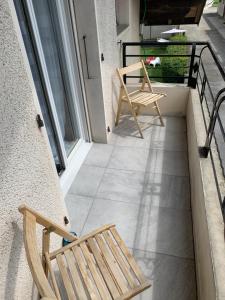 un par de sillas sentadas en un balcón en Coquet appartement aux pieds des montagnes, en Scionzier