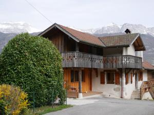 ein Haus mit einem Balkon mit Bergblick im Hintergrund in der Unterkunft Appartement 4 personnes Lac d'Annecy in Lathuile