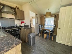 a kitchen with a table and a dining room at Lovely 8 Berth Caravan With Decking And Nearby Scratby Beach Ref 50005a in Great Yarmouth