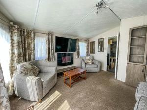 a living room with two chairs and a tv at Lovely 8 Berth Caravan With Decking And Nearby Scratby Beach Ref 50005a in Great Yarmouth