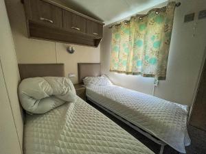 2 camas en una habitación pequeña con ermottermottermott en Lovely 8 Berth Caravan With Decking And Nearby Scratby Beach Ref 50005a en Great Yarmouth