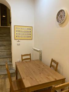 einen Esstisch mit Stühlen und eine Uhr an der Wand in der Unterkunft Casa Gaia A due passi dal Duomo in Neapel