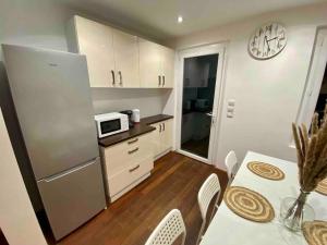 eine Küche mit einem Kühlschrank und einem Tisch mit einer Mikrowelle in der Unterkunft Superbe Maison - Biarritz/Plage in Biarritz