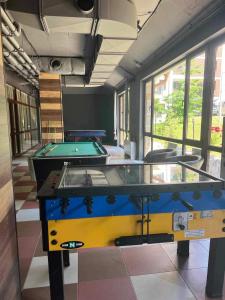 two ping pong tables in a room with windows at Арборо Боровец Гардънс Д35 in Borovets
