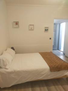 a white bed in a room with a window at Petite maison à Drancy in Drancy