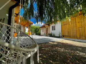 a hammock hanging from a tree in front of a house at Acasa la Bunica, Cheile Turzii in Petreştii de Jos +10 photos