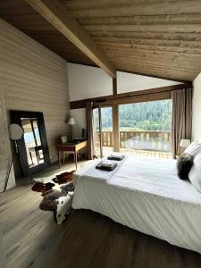 a bedroom with a large bed and a large window at Chalet Alpaga 3 classé 4 étoiles in Châtel