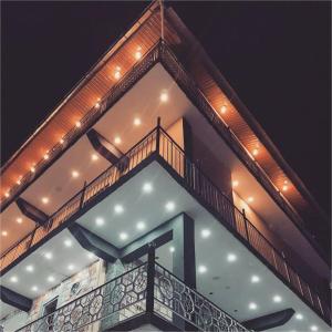 a building with a balcony with lights on it at Dunleigh Apartments in Murree