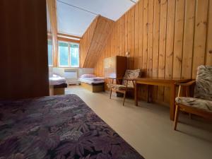 a bedroom with a bed and a desk and a chair at Dobrá Voda u Záblatí - lesní areál in Záblatí