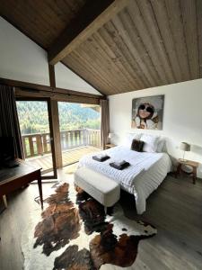 a bedroom with a bed and a large window at Chalet Alpaga 3 classé 4 étoiles in Châtel