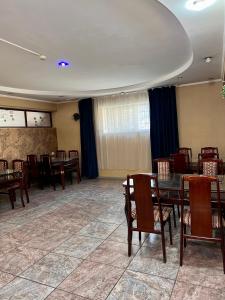 comedor con mesas y sillas de madera en InJoy Hostel en Shymkent